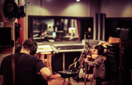 レコーディングスタジオで演奏準備をするミュージシャンとエンジニアの様子