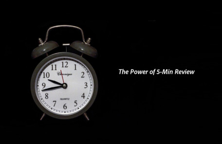 暗い背景に置かれたアナログ目覚まし時計。短時間集中の練習や時間管理を連想させるビジュアル。