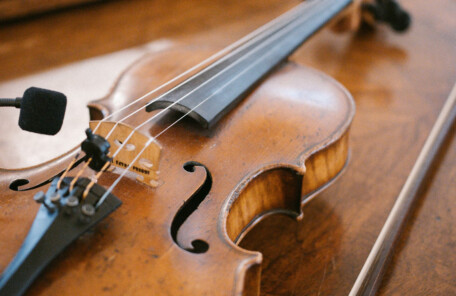 木製テーブルの上に置かれたバイオリンと弓のクローズアップ