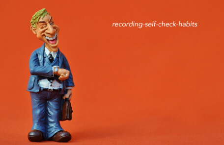 オレンジ背景に青いスーツのフィギュア、右上に「recording-self-check-habits」の文字